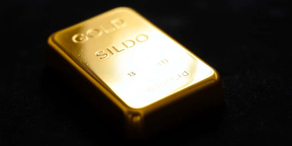 Lingot d'or sur une surface en velours sombre.