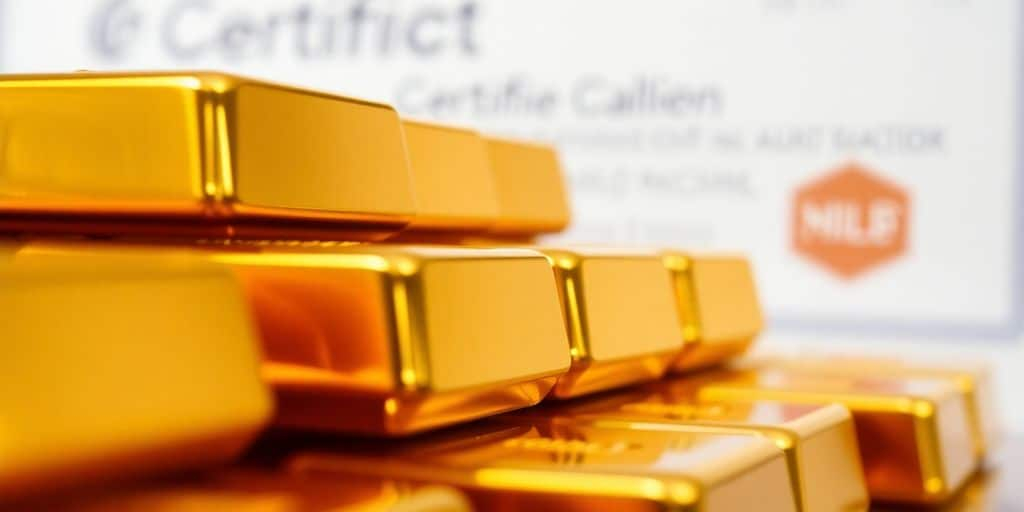 Lingots d'or empilés avec un éclairage doux.