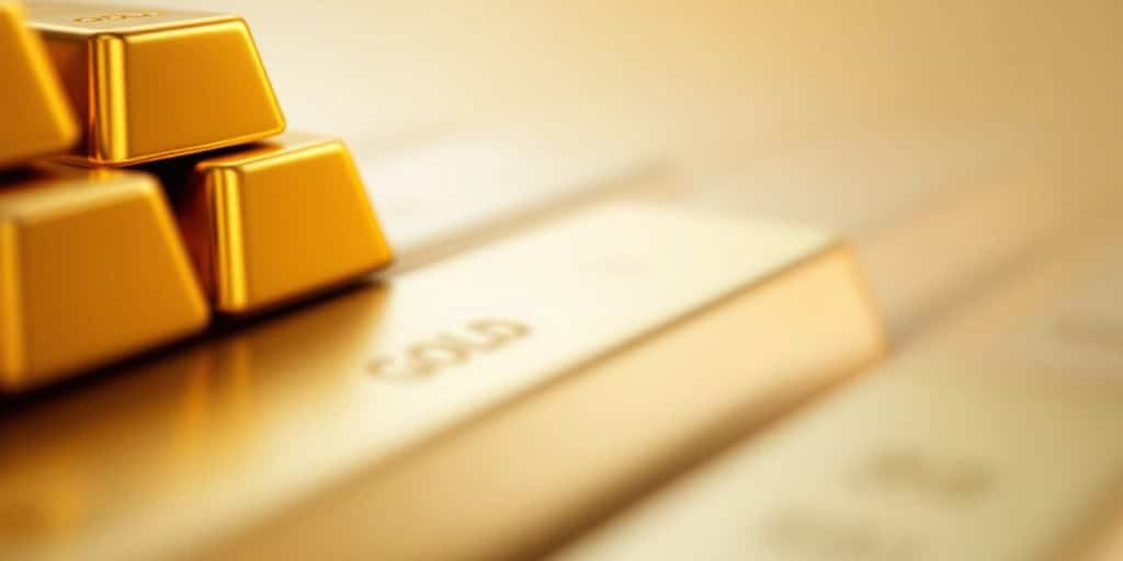 Barres d'or empilées sur un fond doux.