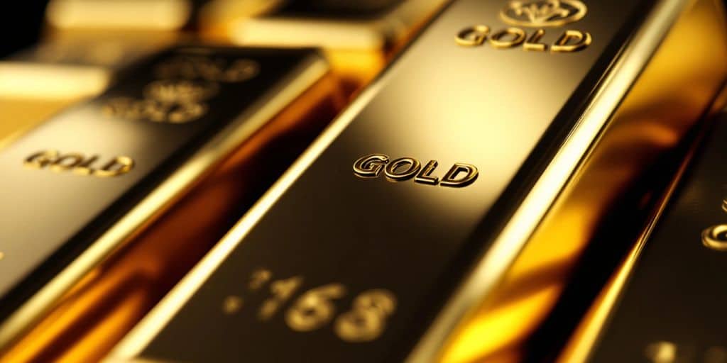 Des barres d'or empilées sur un fond sombre.