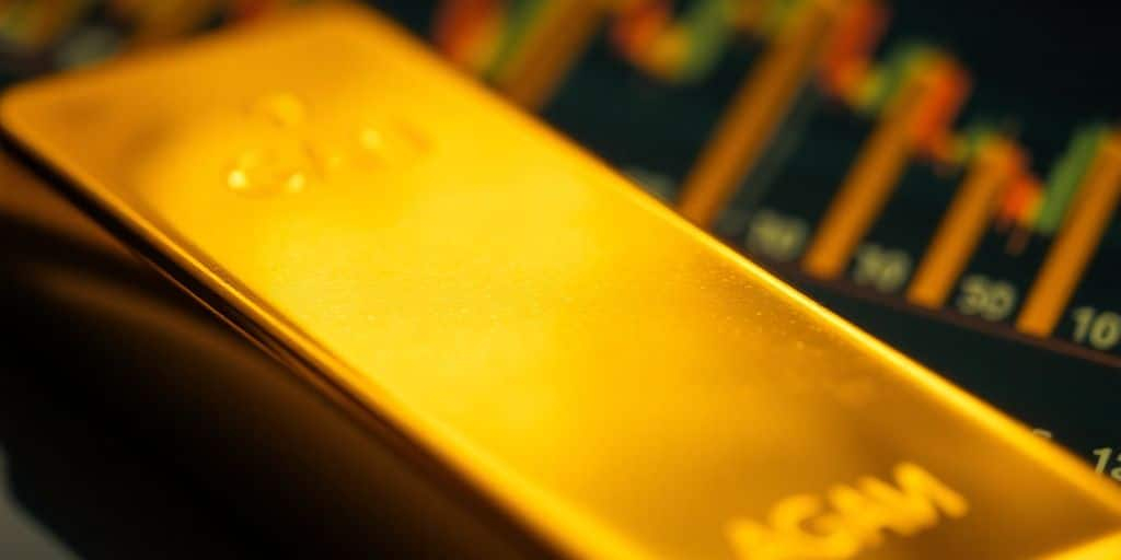 Barre d'or avec un fond flou de courbes financières.