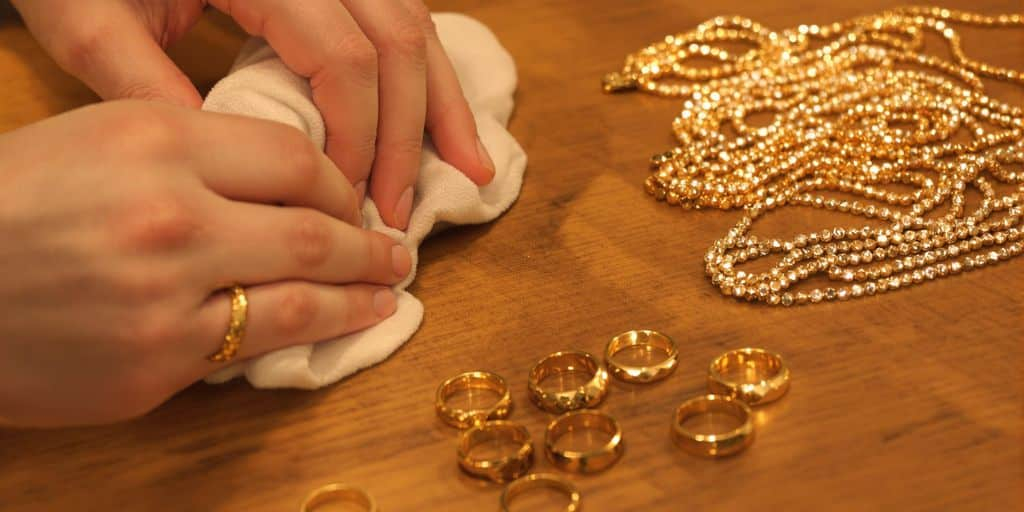 Bijoux en or nettoyés à la main sur une table en bois.