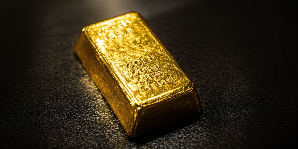 Gros plan d’un lingot d’or usé sous douce lumière naturelle.