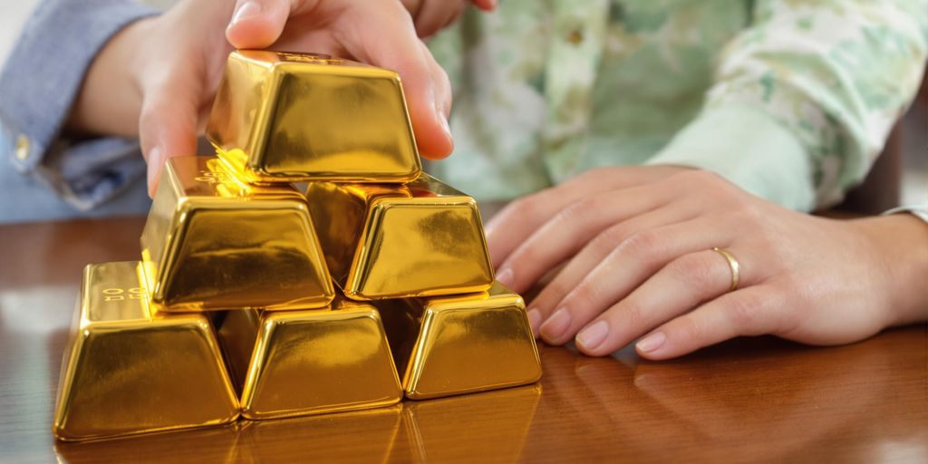 Mains de famille touchant des lingots d'or sur une table