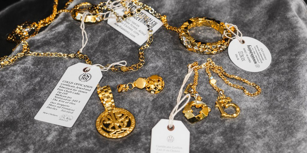 Bijoux en or certifiés exposés sur un tissu luxueux.