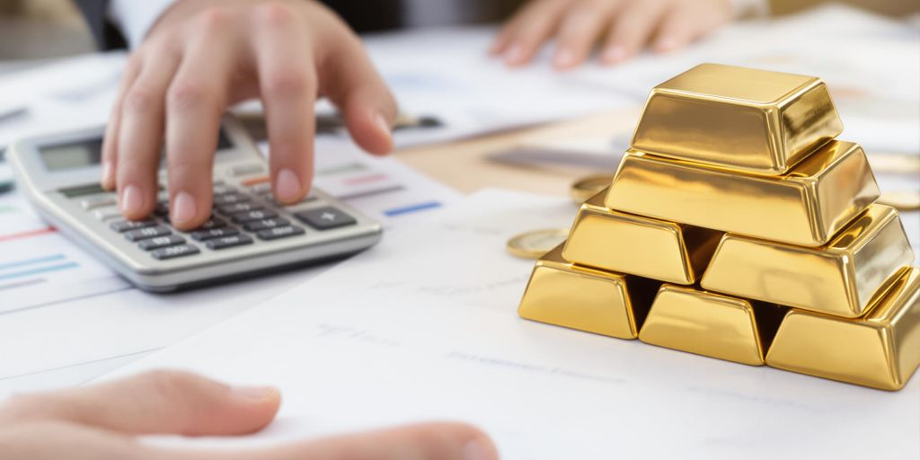 Lingots d’or sur un bureau d’entrepreneur avec main visible
