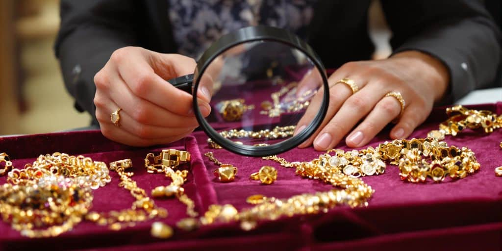 Expert inspecte bijoux en or sur une table en velours.