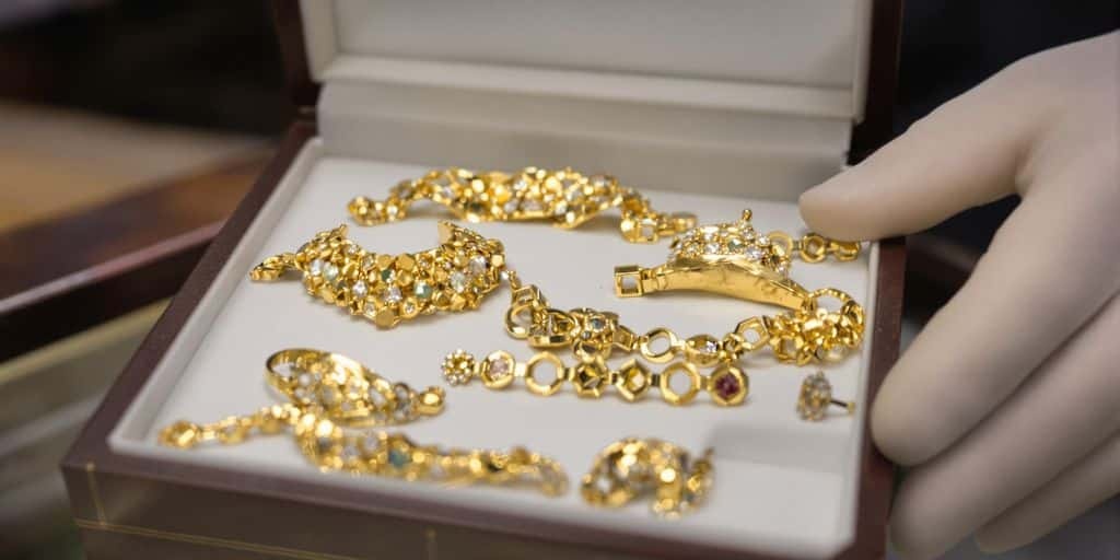 Bijoux en or protégés dans une boîte de velours sécurisée.