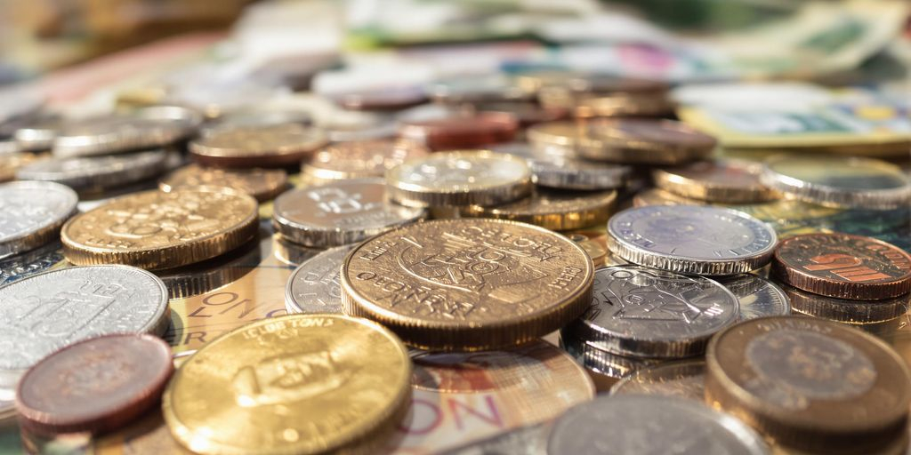 Photo réaliste de pièces et billets exposés sur surface élégante.