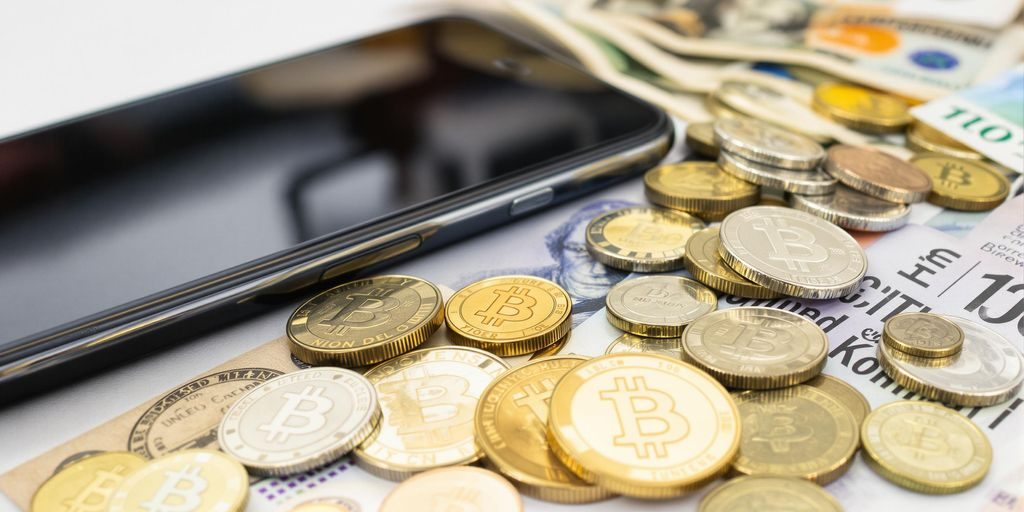 Photo réaliste: billets, pièces et smartphone avec cryptomonnaies modernes actuelles.
