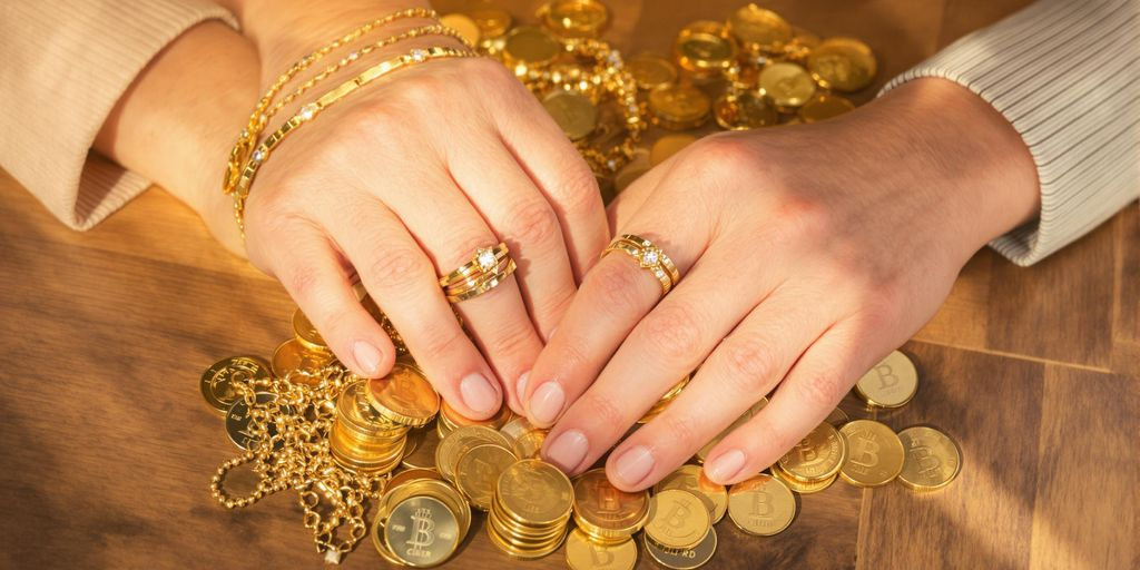 Deux mains de couple tenant des bijoux et pièces en or.