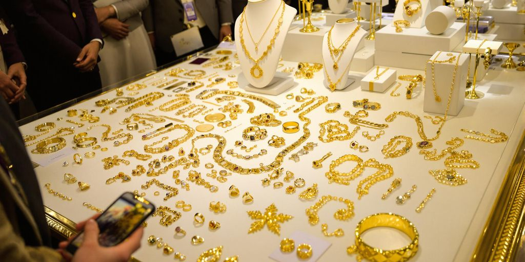 Bijoux en or exposés sur une table lors d'enchères élégantes.