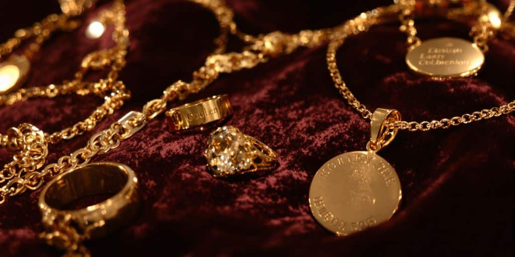 Bijoux en or personnalisés exposés sur un tissu luxueux.