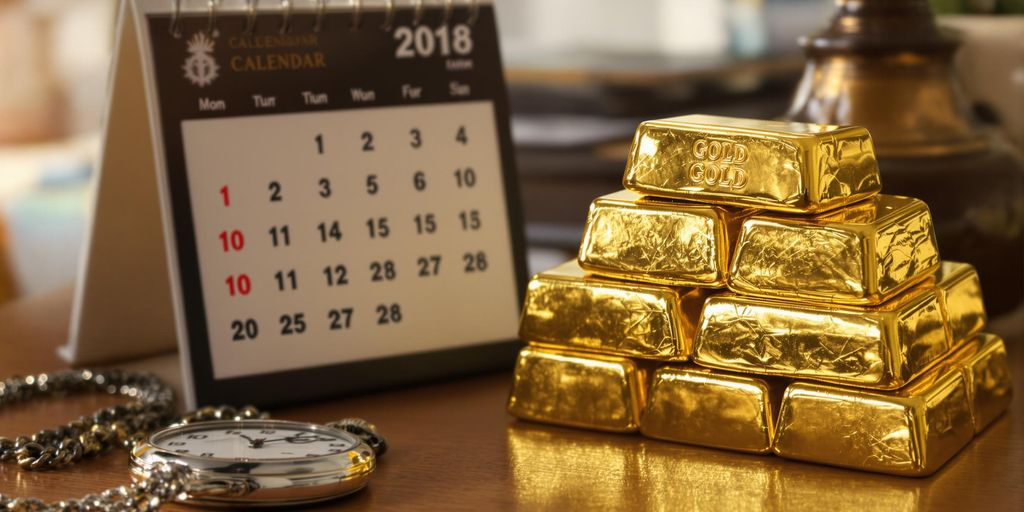 Lingots d'or posés près d'un calendrier et d'une montre.