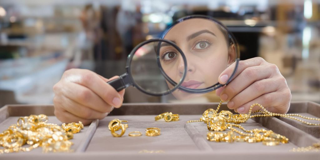 Bijoux en or examinés par un expert en boutique.