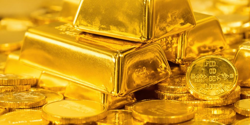 Lingots d'or empilés avec des pièces de monnaie.
