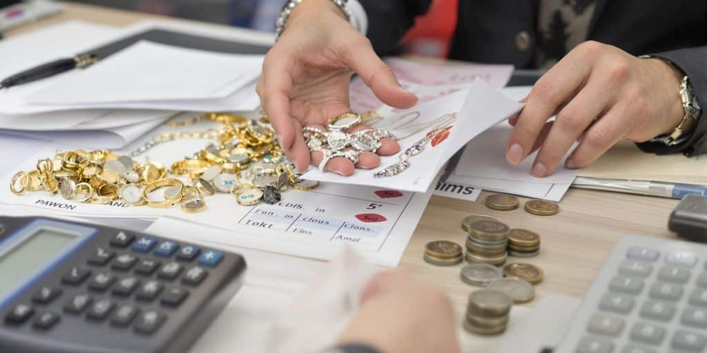 Personne remet des bijoux et papiers au comptoir du prêteur.