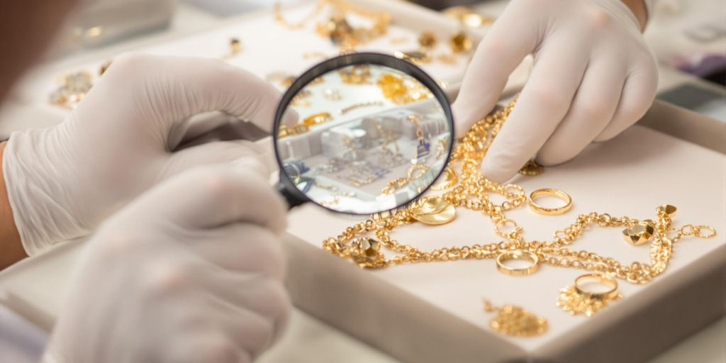 Expert examine un bijou en or avec une loupe.