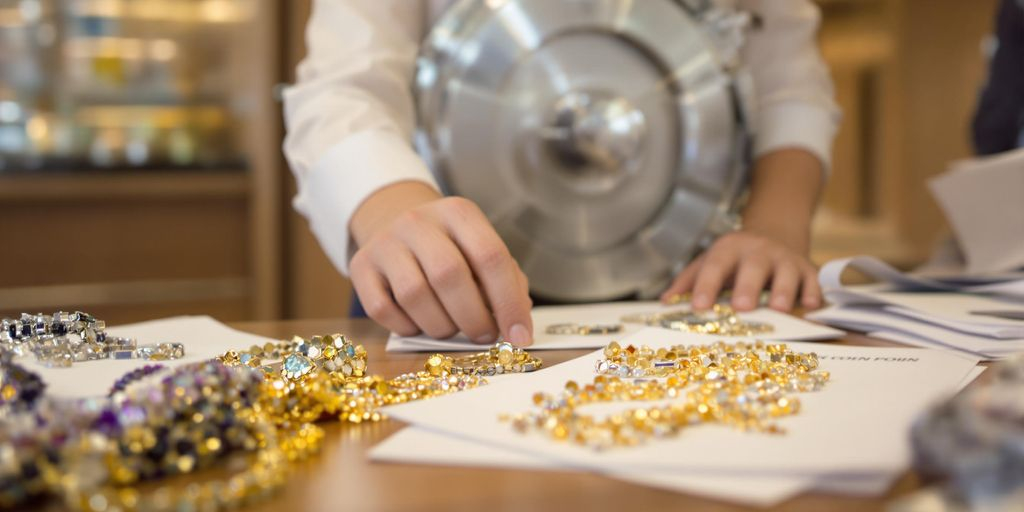 Bijoux et documents examinés par un employé de banque.