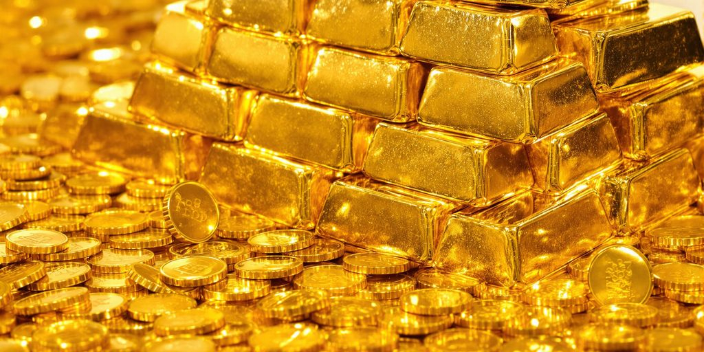 Lingots d'or empilés et pièces d'or brillantes