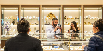 Bijoutier examinant des bijoux en or avec des clients
