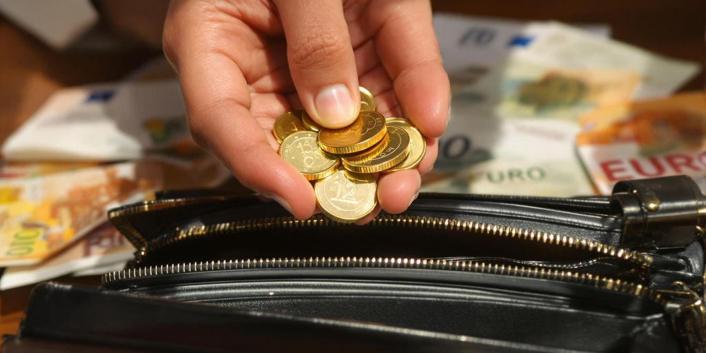 Main tenant des pièces d'or au-dessus de billets d'euros