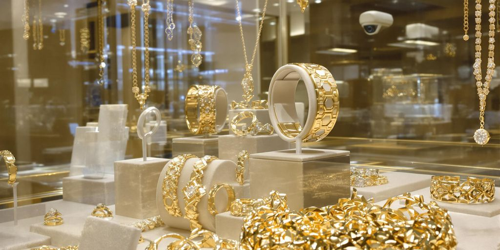 Bijoux en or dans une vitrine sous surveillance de sécurité.