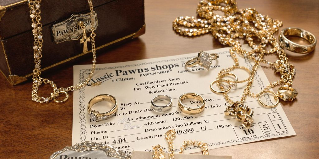 Bijoux en or et argent posés sur une table en bois.