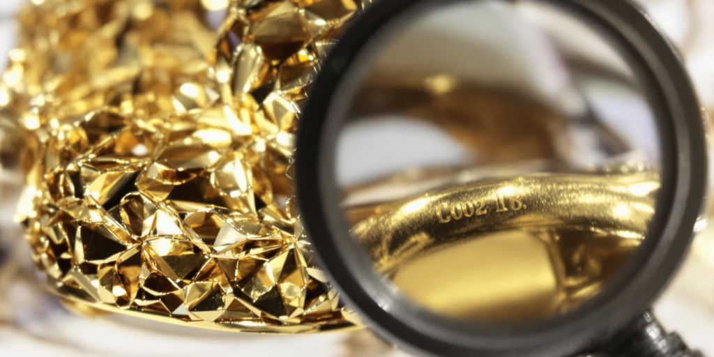 Loupe examinant un poinçon sur une bague en or