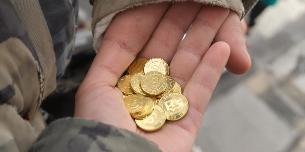Main tenant des pièces d’or dans une rue animée