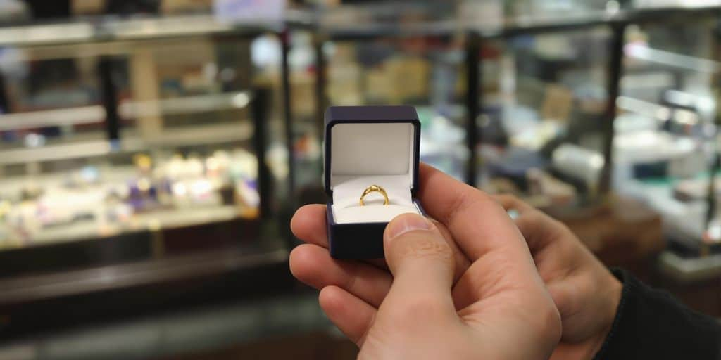 Mains tenant discrètement une boîte à bijoux dans un magasin.