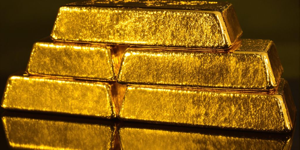 Lingots d'or brillant sur fond sombre.