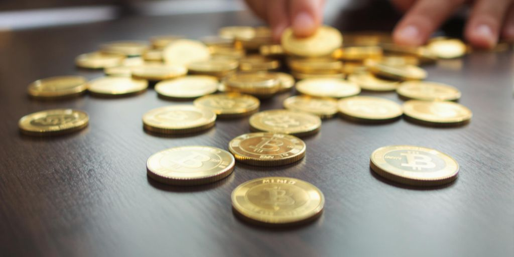 Pièces d'or posées sur une table en bois sombre.