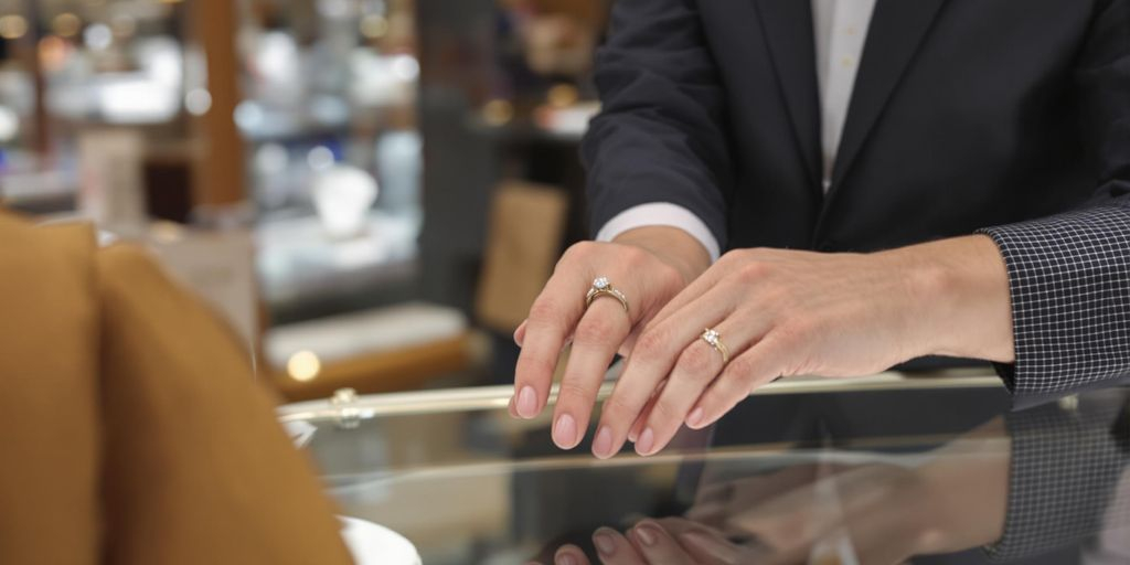 Bijoux précieux échangés entre deux mains dans une bijouterie.
