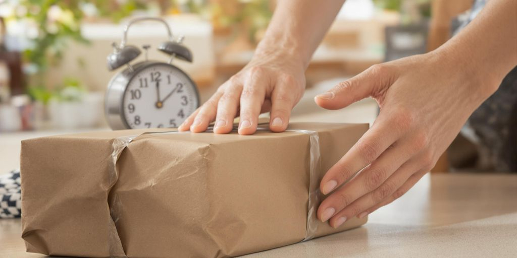 Personne récupérant un colis avec une horloge en arrière-plan.