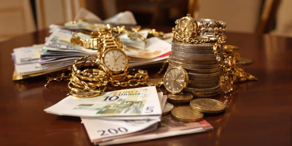 Montre ancienne et bijoux en or sur des billets euros