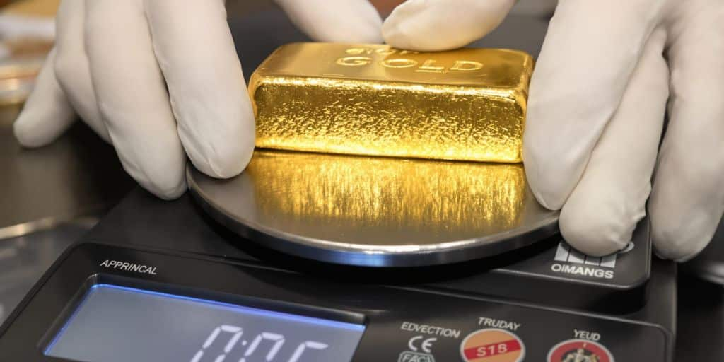 Lingot d’or pesé sur une balance de précision.