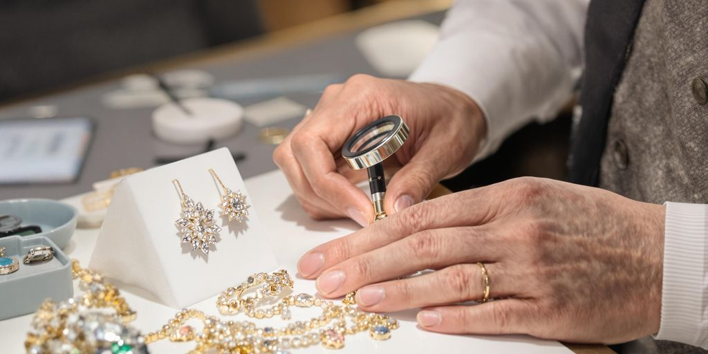 Expert évaluant des bijoux en or et pierres précieuses