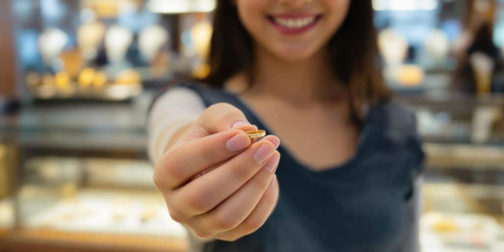 Adolescent tenant une bague en or chez le bijoutier.