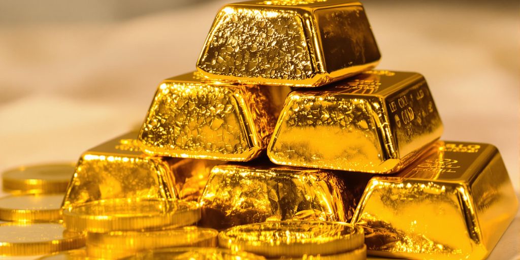 Lingots d'or brillants empilés avec des pièces d'or.