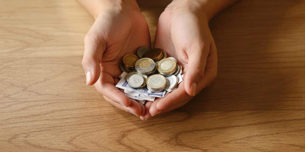 Mains protégeant des pièces et des billets