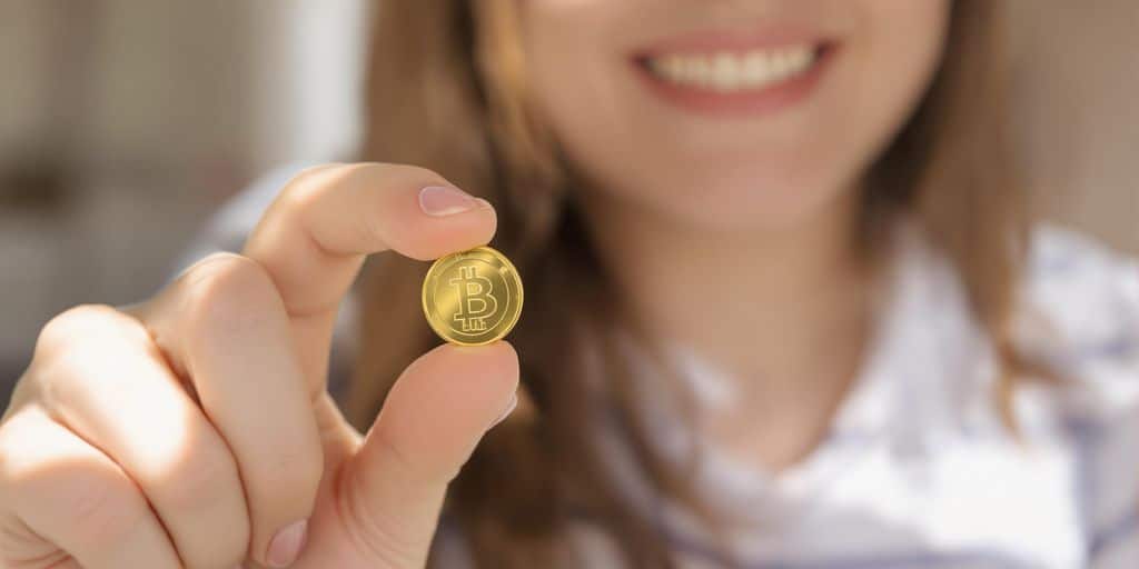 Jeune femme souriante, tenant une pièce d'or