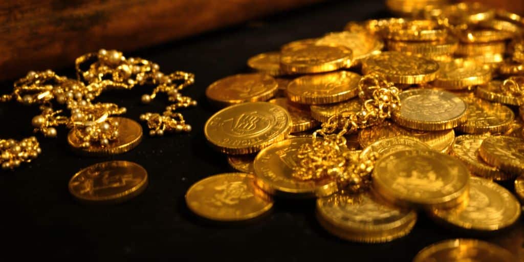 Pièces d'or, lingots, bijoux anciens, coffre-fort, héritage, richesse, investissement.