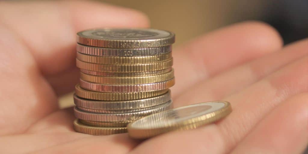 Main tenant une pile de pièces de monnaie