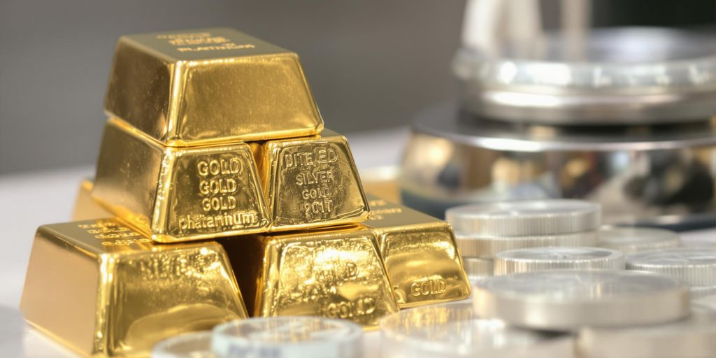Lingots d'or, barres d'argent, et platine sur une balance.
