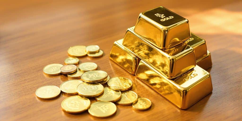 Lingots et pièces d'or sur table en bois