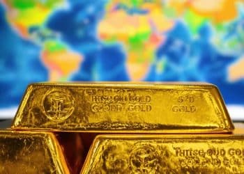 Lingots d'or empilés sur une carte du monde.