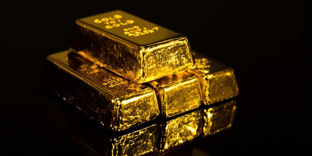 Lingots d'or empilés sur une surface sombre et brillante