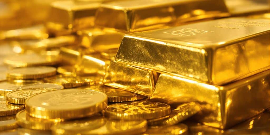 Lingots d'or empilés et pièces d'or brillantes