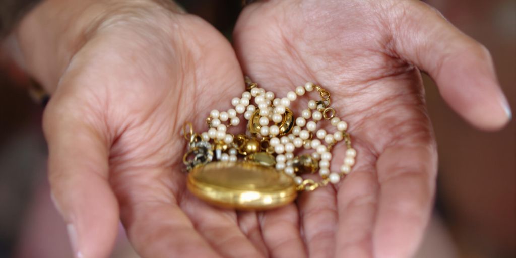 Mains âgées tenant des bijoux anciens